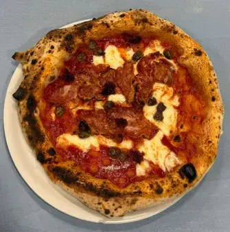 Pizza napoletana con salame piccante, mozzarella e olive nere su piatto bianco, ristorante Lido26 Da Rapi a Reggio Emilia