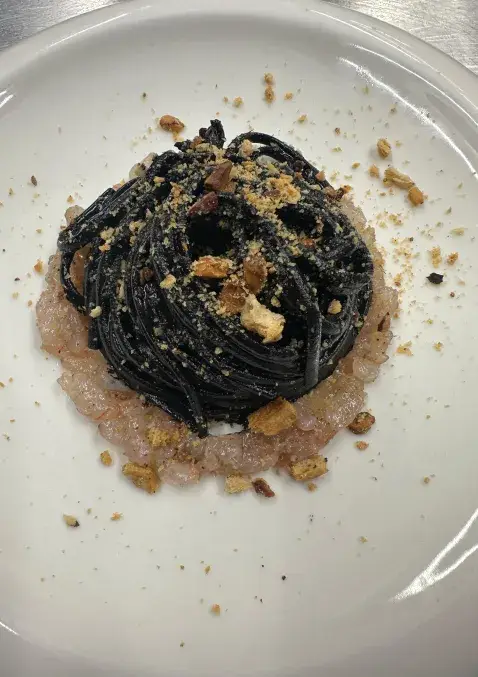 Piatto di spaghetti al nero di seppia con tartare di gamberi e crumble croccante, ristorante Lido26 Da Rapi